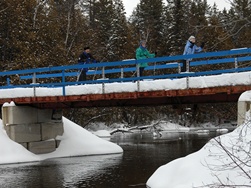 Skieurs sur le pont enjambant la Rivière-Bleue.